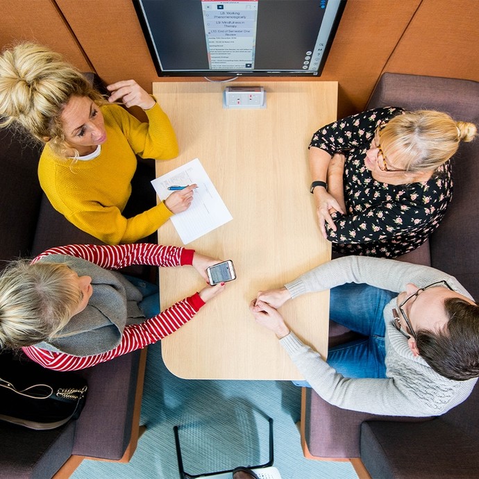 Aerial shot of 4 students sitting in a booth