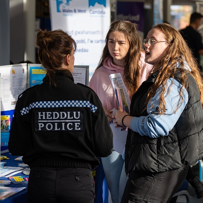 Police officer in discussion with two students