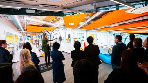 A group of people standing in the immersive room, with displays on the walls around them.