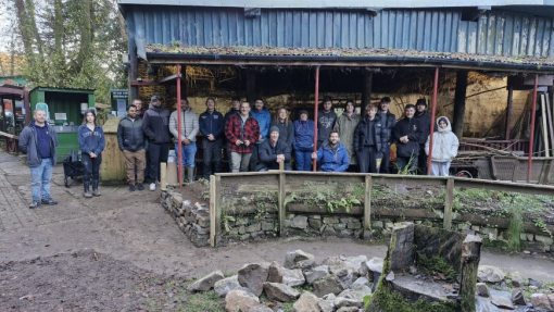 A group of students standing in front of an out door building.