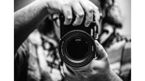 a black and white image of someone holding a camera