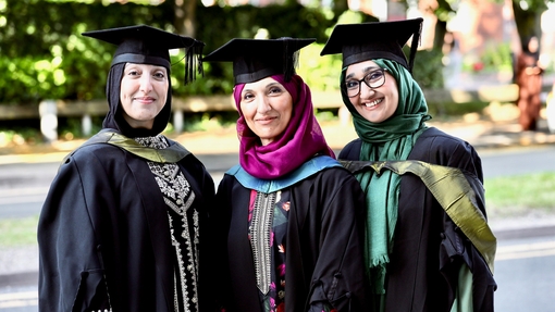 Three students in their graduation gowns at the Birmingham graduation