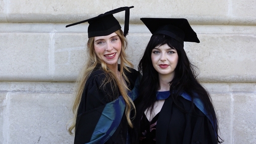 Two women wearing caps and gowns