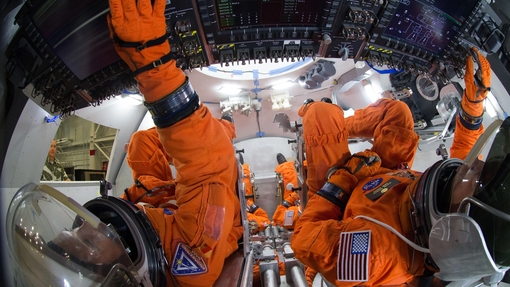 Two Nasa employees working inside a space ship environment.