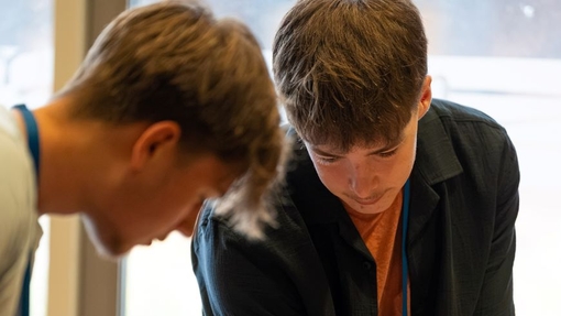 Two students working on a wooden structure.
