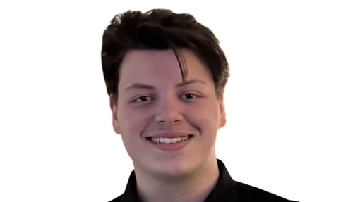 A smiling student dressed in a dark coloured shirt.
