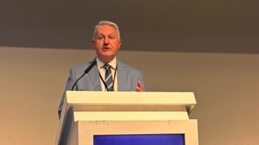 Dr Philip Scott talking in front of a blue podium