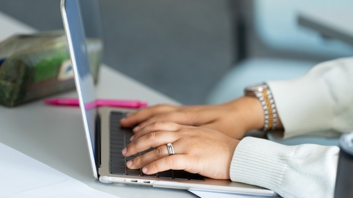 Person's hands displayed working on computer