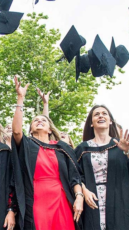 a group of students throwing hats in the air