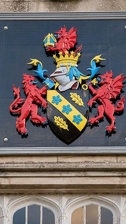 Brightly painted UWTSD coat-of-arms on the wall of the college in Lampeter.