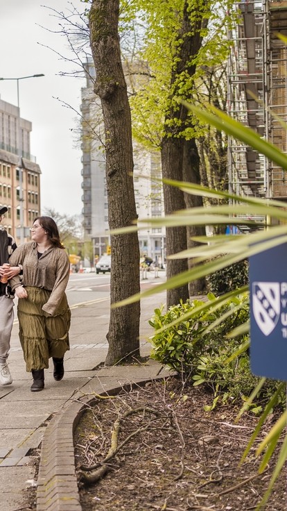 Four students walking outside Cardiff campus 