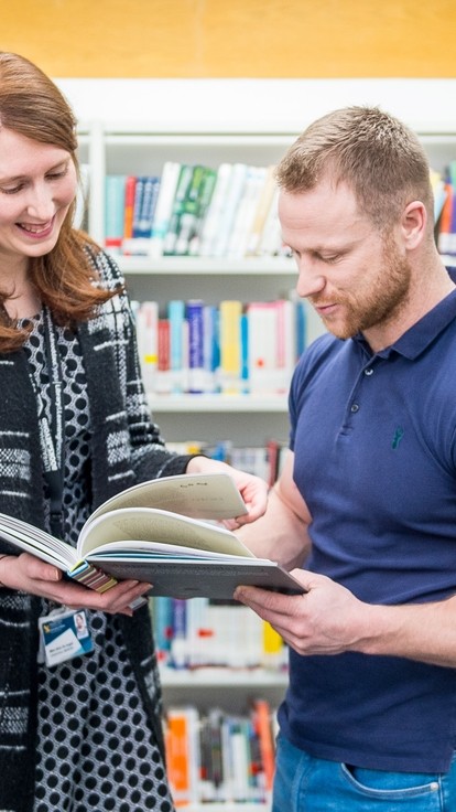 man women reading book in library 