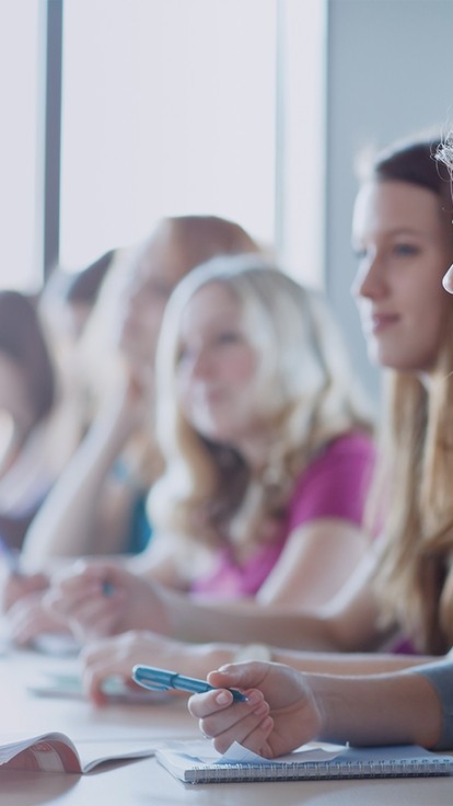 Row of students working at a desk