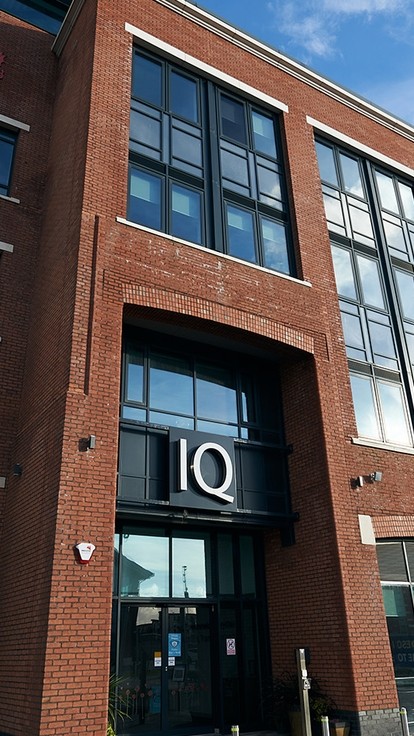 The glass and red brick exterior of the IQ building.