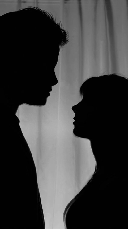 black and white image of a female and male looking at each other