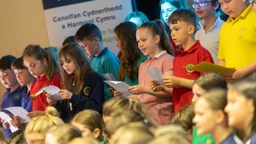 Plant oed ysgol gynradd yn canu mewn grŵp.