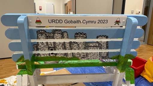 Cefn un o’r meinciau a grëwyd yn rhan o Brosiect 23. Mae castell wedi’i beintio arno mewn lliwiau llachar.