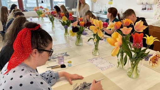 A group of students participating in a flower painting workshop in the surface pattern studio at UWTSD.