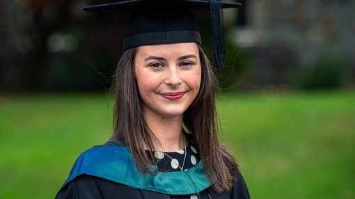 Ffion Anderson mewn gwisg academaidd.