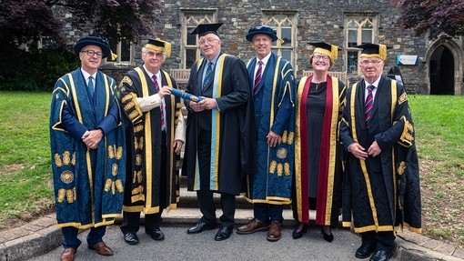Dai Lewis gyda Gwilym Dyfri Jones ac uwch aelodau eraill Brifysgol, i gyd mewn gwisg academaidd ffurfiol.
