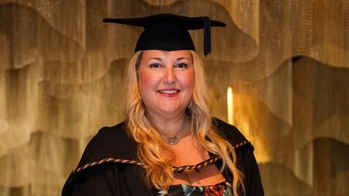 Rebecca Trott smiles in her graduation robes.