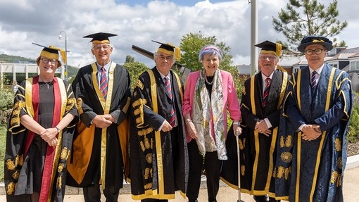 Gan bwyso ychydig ar ffon gerdded cwad, mae Margaret Evans yn gwenu tuag at y camera gyda’r Athro Elwen Evans, Arwel Ellis Owen a Medwin Hughes ar ei hochr chwith a’r Hybarch Randolph Thomas ac Emlyn Dole ar ei hochr dde.