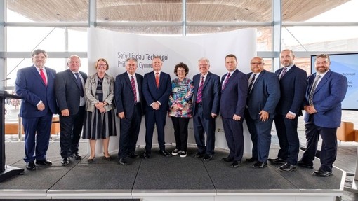 Group of men in suits, with two women, from FE colleges and UWTSD.