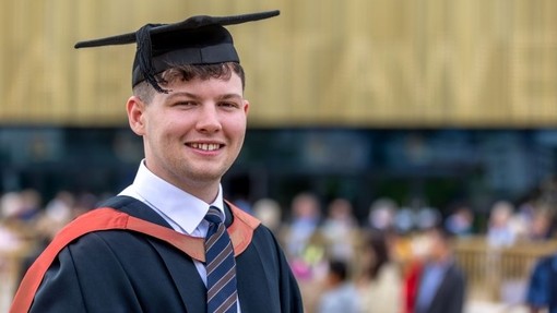 Nye Evans in his academic gown and hat at graduation.