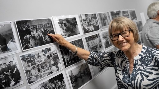 An alumna points to her younger self in a black-and-white photo.
