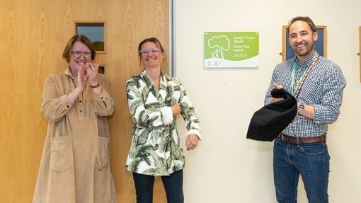 Yr Athro Elwen Evans yn cymeradwyo wrth i Owen Derbyshire wenu yn ystod y digwyddiad.