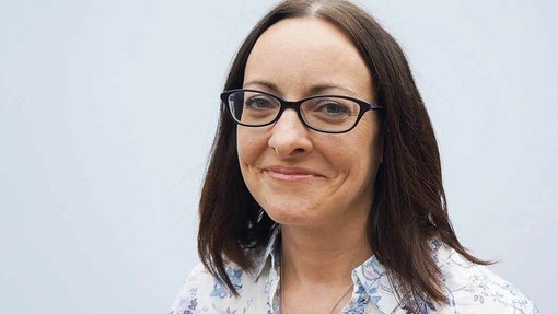 Llun pen ac ysgwyddau o Kara Lewis yn gwenu at y camera.