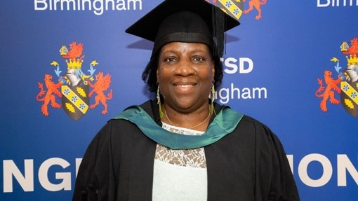 Peolita Douglas yn gwisgo cap a gŵn graddio.