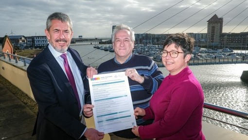 Yr Athro Ian Walsh, Philip McDonnell a Kate Williams yn dal copi A3 wedi’i lofnodi o’r Siarter Teithio Llesol.