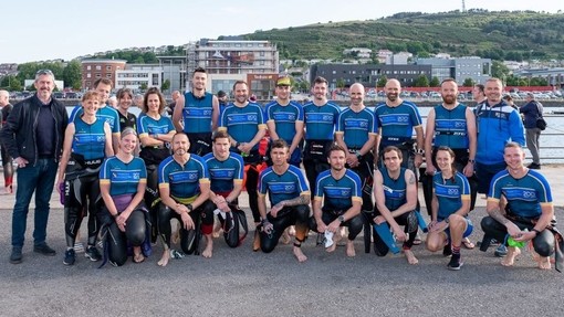 Profost PCYDDS Abertawe, Ian Walsh, ac ugain o athletwyr triathlon o PCYDDS, yn SA1 Glannau Abertawe.