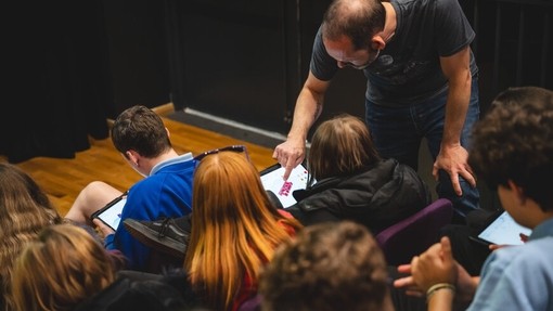 Plant ysgol uwchradd yn defnyddio iPads dan gyfarwyddyd oedolyn.
