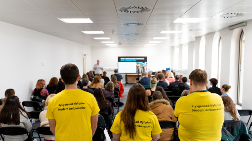 Student Ambassadors standing behind a seated crowd of people