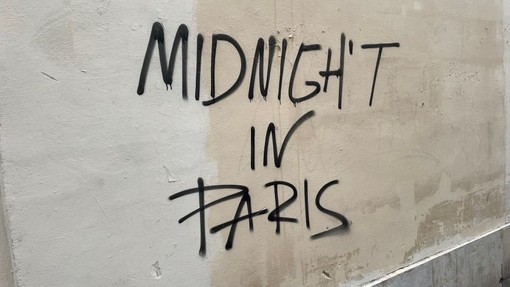 Wal lwydwyn glytiog gyda’r geiriau Midnight in Paris wedi’u sgriblan arni.