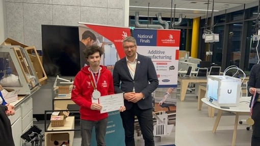 One of the UWTSD competitors with his medal and certificate stands next to Ben Blackledge.