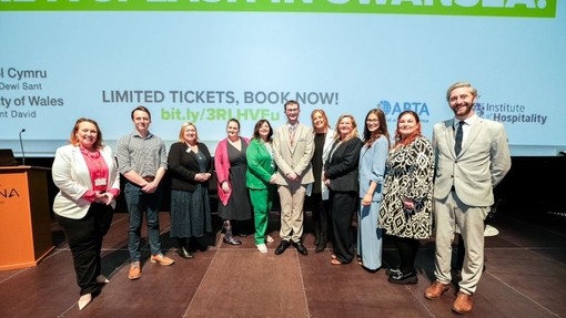 Mae un ar ddeg o bobl yn gwenu ar lwyfan Cynhadledd Future You 2023.