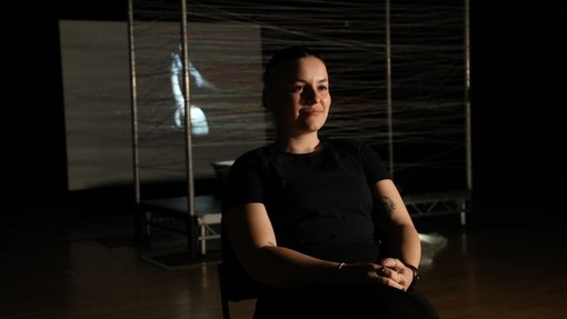 Elicia Axon sitting in a chair on set