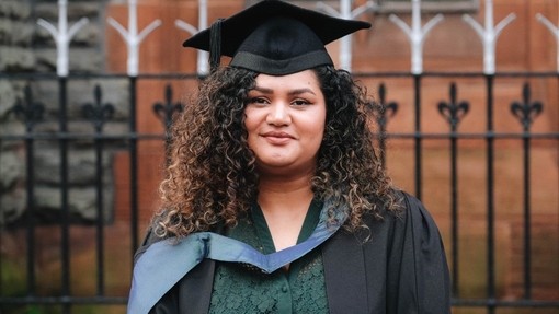 Khush Shariq yn gwisgo gwisg academaidd, cwfl, a het.