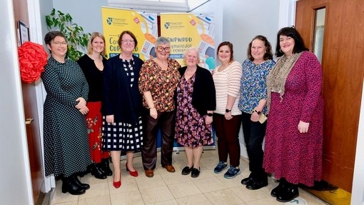 Yr Athro Elwen Evans a Carolyn Harris AS yn sefyll dan wenu gyda chwe menyw arall.