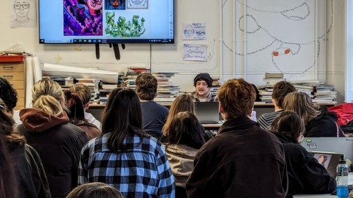Students in a classroom listening to Karl James Mountford.