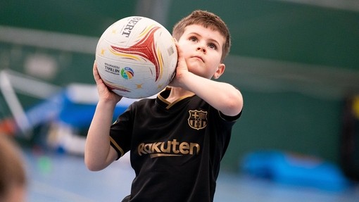 Young boy about to throw a ball in the UWTSD Sports Centre in Carmarthen