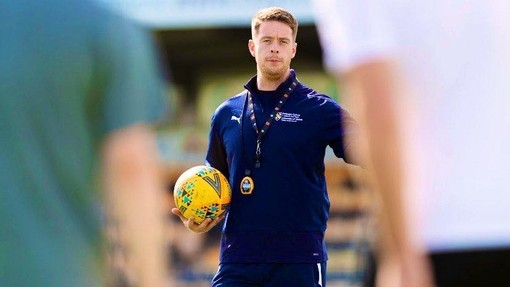 A photo of Martyn Bowles in a training session holding a football in his arm