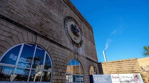 The sand-coloured masonry and large half-moon windows of the Dylan Thomas Building. 