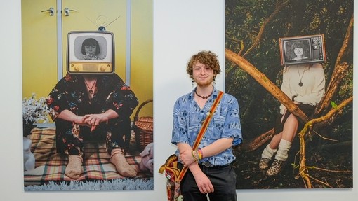 A student standing in front of the exhibition.
