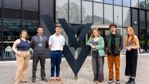 Adventure Filmmaking Students with lecturer Brett Aggersberg standing together in front of Yr Egin