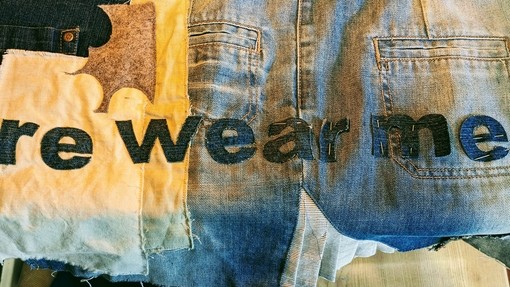 Patches of material overlaid with the words re wear me on them