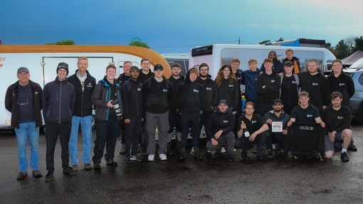 Happy student Team MCR members standing in the sunshine at Castle Combe.